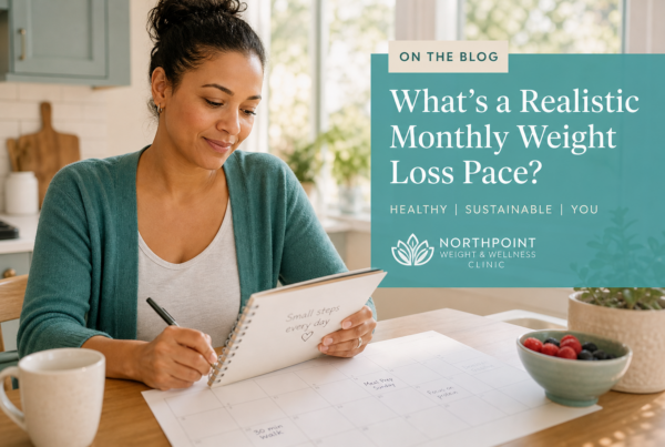 Person reviewing a weekly health plan in a bright kitchen, representing a realistic monthly weight loss pace