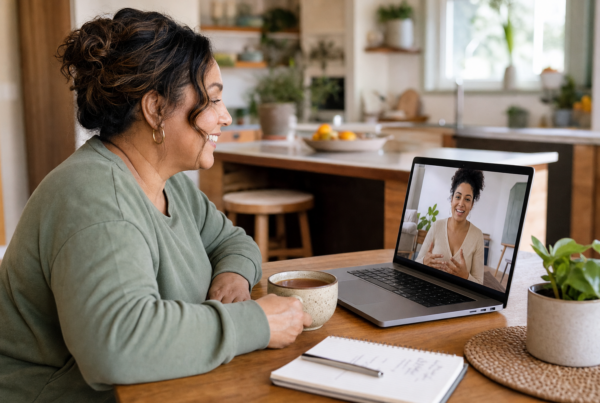 Woman having a friendly video call with an online weight loss coach at her kitchen table